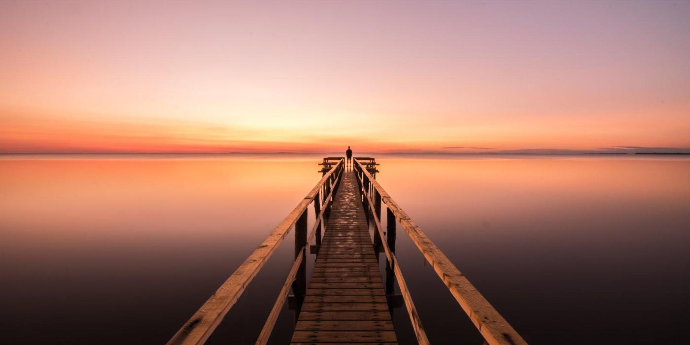 Looking down the length of a Matlock dock on Lake Winnipeg at sunset.